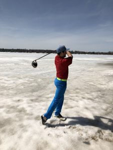 Swinging golf club in winter